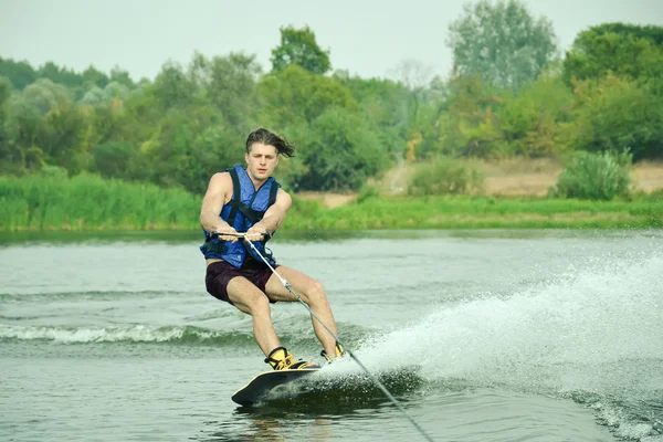 Handsome man wakesurfing in a lake — Stock Photo, Image