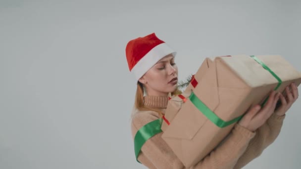 Stanco ragazza Babbo Natale, portando un sacco di grandi scatole regalo pesanti. — Video Stock