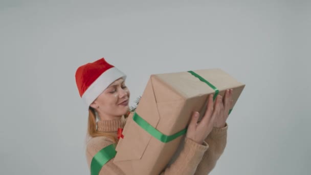 Κουρασμένο κορίτσι Santa Claus κρατώντας ένα μεγάλο βαρύ κουτί δώρου πολύ σκληρά. — Αρχείο Βίντεο
