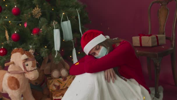 Dívka v lékařské masce zabalená v kostkovaném kostkovaném je smutná na Novém roce. — Stock video