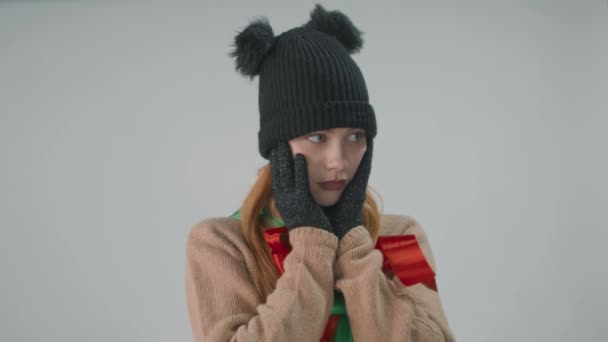 Uma loira de chapéu de inverno e luvas isoladas em cinza balança a cabeça para os lados. — Vídeo de Stock