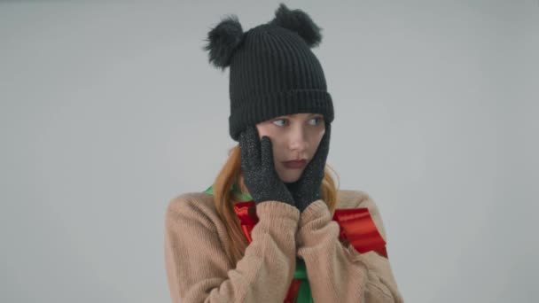 A blonde in winter hat and gloves isolated on grey shakes her head to the sides. — Stock Footage A blonde in winter hat and gloves isolated on grey shakes her head to the sides. Royalty Free Stock Video