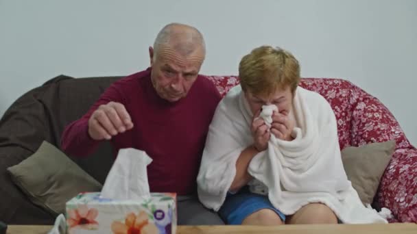 Senior woman is ill, she has a runny nose and sore throat. The husband looks after her. — Stock Video