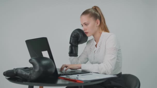 Joven mujer de negocios que trabaja en la computadora en guantes de boxeo después del trabajo que va al boxeo. — Vídeos de Stock