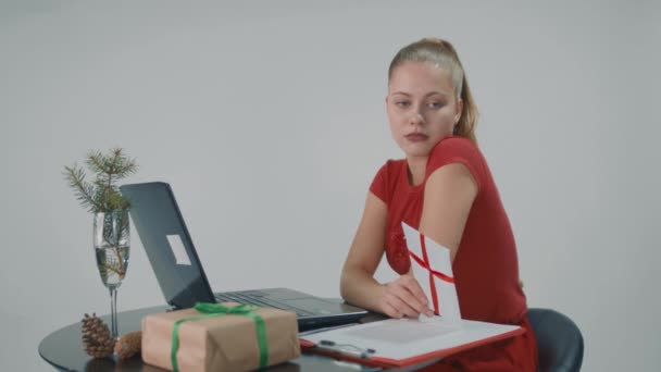 Senhora agradável em vestido vermelho está segurando um cartão de presente e ela quer dar-lhe como um presente. Filmagem De Stock