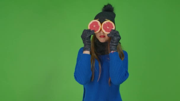 一个有点心烦意乱的年轻漂亮的女人拿着两片柚子盖住她的眼睛. — 图库视频影像
