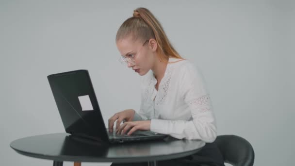 Konzentrierte Geschäftsfrau sitzt mit Brille im Büro am Laptop. — Stockvideo