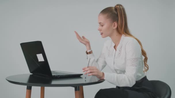 Belle femme d'affaires est assis à la table dans le bureau et parle en ligne d'une voix élevée. — Video