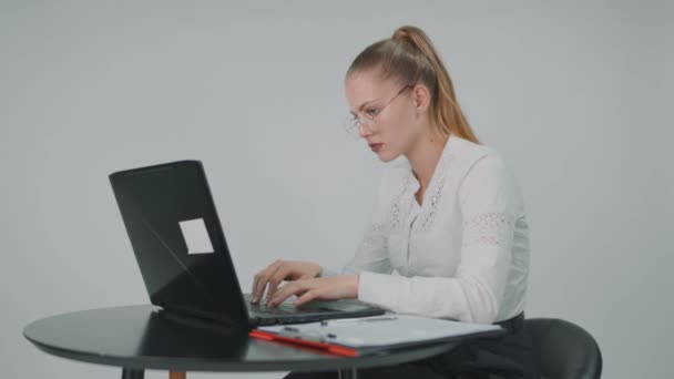 Image de jeune belle femme d'affaires portant des lunettes est fatigué tout en travaillant avec un ordinateur portable au bureau. — Video