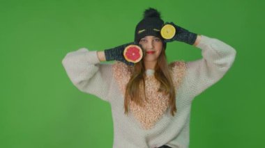 Güzel gözlü güzel bayan kollarında iki meyve limon ve greyfurt tutuyor..