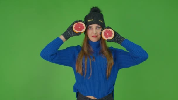 Malý ženský charakter válcování grapefruit plátek šaty v modrém svetru a rukavice. — Stock video