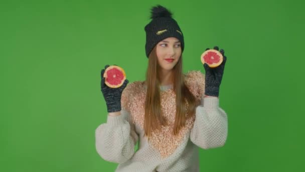 Beautiful model girl with long blond hair is dancing holding grapefruits in her arms. — Stock Video