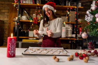 Kadın Noel süslemeli kek pişiriyor.