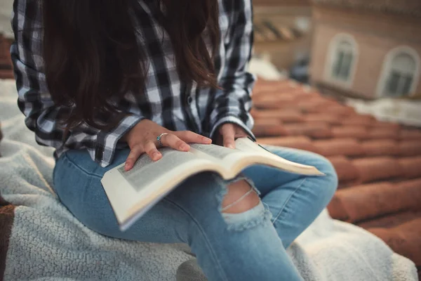 女人在她的房顶上轻松地读着书 — 图库照片