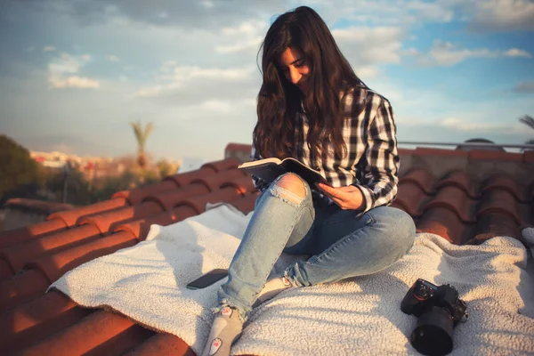 彼女の家の屋根の上で読書のリラックスの瞬間に女性 — ストック写真
