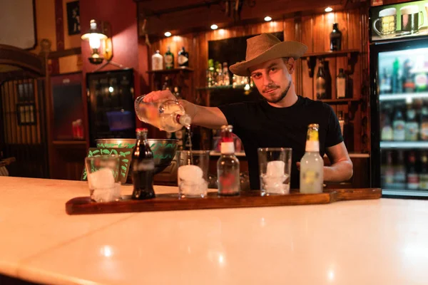 Waiter cowboy serving drink in a bar