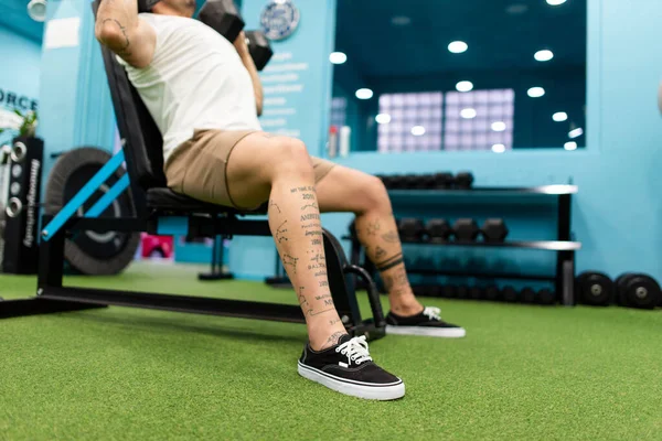 Genç yakışıklı sporcu vücut geliştirme yarışması için spor salonunda antrenman yapıyor.