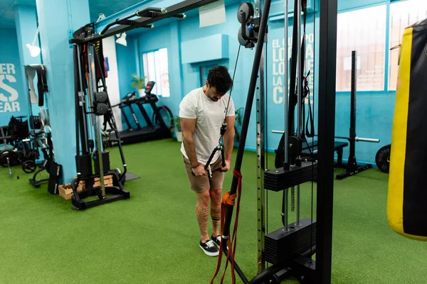 Genç yakışıklı sporcu vücut geliştirme yarışması için spor salonunda antrenman yapıyor.