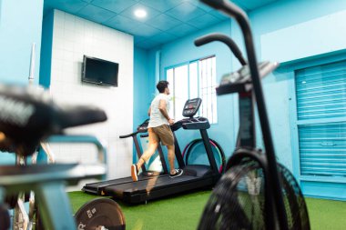 Genç yakışıklı sporcu vücut geliştirme yarışması için spor salonunda antrenman yapıyor.