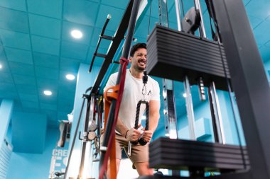 Genç yakışıklı sporcu vücut geliştirme yarışması için spor salonunda antrenman yapıyor.