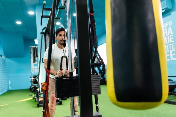 Genç yakışıklı sporcu vücut geliştirme yarışması için spor salonunda antrenman yapıyor.