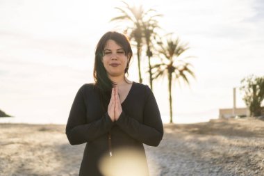 Kumsalda yoga yapan mutlu kız.