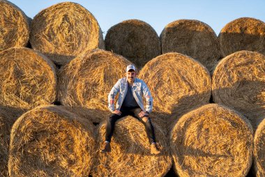 Neşeli, güzel ve hayat dolu adam samanlıkta fotoşopun tadını çıkarıyor.