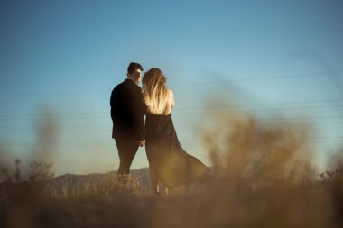 Birbirine aşık bir çift göl kenarında yürüyor.