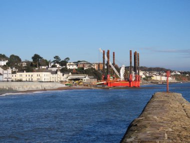 DAWLISH, DEVON, İngiltere - Dawlish 'teki Wavewalker 1 platformu mevcut deniz duvarını yükseltmek için