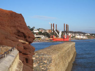 DAWLISH, DEVON, İngiltere - Dawlish 'teki Wavewalker 1 platformu mevcut deniz duvarını yükseltmek için