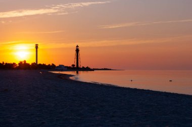 Deniz fenerleriyle güzel bir deniz doğumu. Dzharylgach Adası, Kherson Bölgesi 'ndeki deniz feneri. Ukrayna 'da deniz kıyısında eski bir deniz feneri. Deniz fenerleriyle güzel bir deniz doğumu