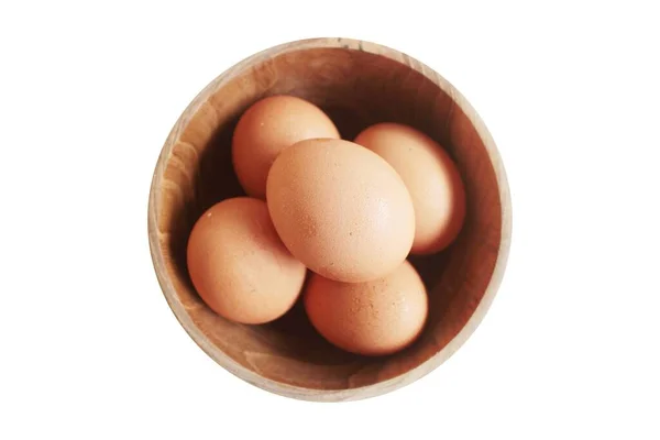 Beyaz arka planda tahta bir kasede ördek yumurtaları.