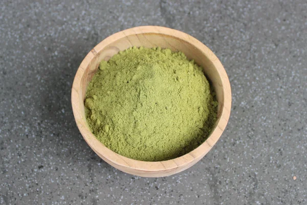 Tahta bir kâsede Moringa yaprağı tozu.