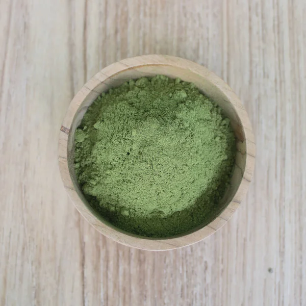 Tahta bir kâsede Moringa yaprağı tozu.