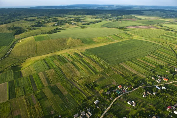 Вид з повітря на зелені та жовті ділянки полів та сільській місцевості Стокове Фото