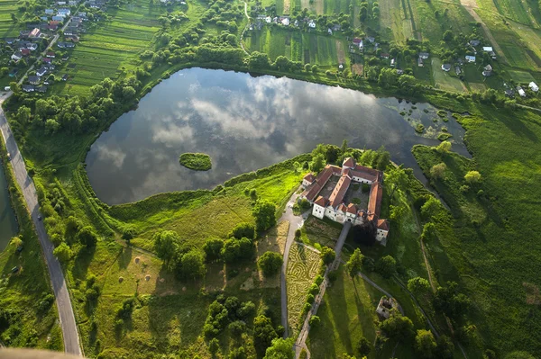 Vista aerea di campagna sul vecchio castello con tetto rosso sul lago — Foto Stock
