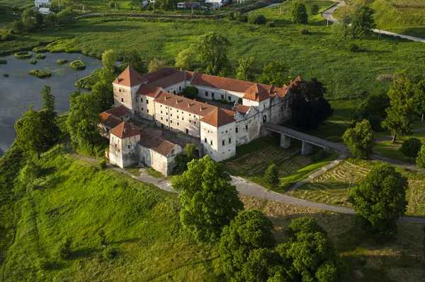 Luchtfoto van het platteland op oud kasteel met rode dak boven het meer — Stockfoto