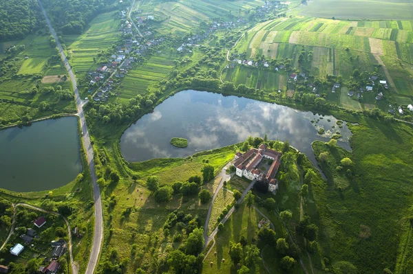 Vista aérea do campo no castelo velho com telhado vermelho sobre o lago — Fotografia de Stock