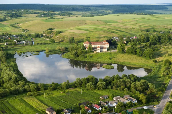 Vista aérea do campo no castelo velho com telhado vermelho sobre o lago — Fotografia de Stock