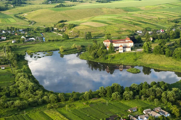 Letecký pohled na krajinu na starý hrad s červenou střechou nad jezerem — Stock fotografie