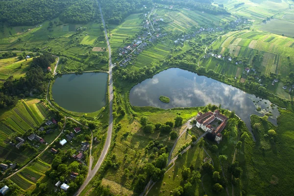 Letecký pohled na krajinu na starý hrad s červenou střechou nad jezerem — Stock fotografie