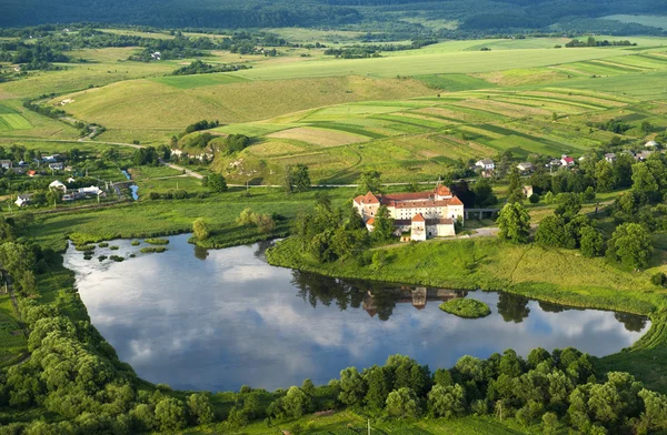 Letecký pohled na krajinu na starý hrad s červenou střechou nad jezerem — Stock fotografie