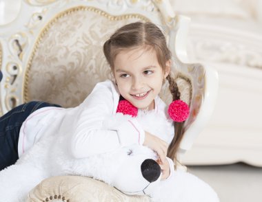 Oyuncak ayı ve koltuk çiçek ile mutlu kız