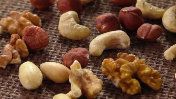 Amandes, noix de cajou, noix de Grenoble et noisettes sur toile de jute — Video