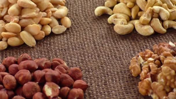 Amandes, noix de cajou, noix de Grenoble et noisettes sur toile de jute — Video