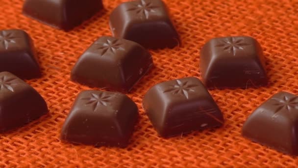 Шоколадні цукерки на помаранчевому фоні — стокове відео