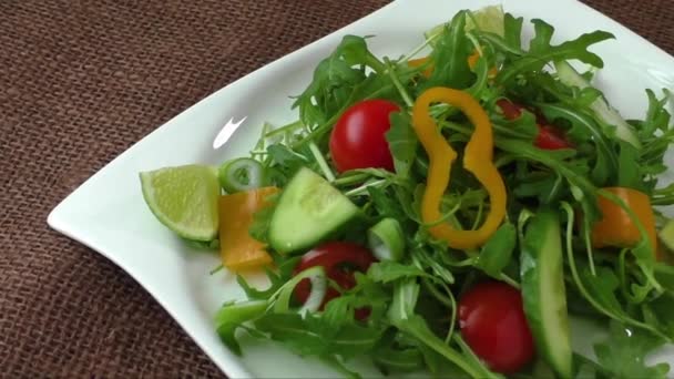 Салат из рукколы на белой тарелке — стоковое видео