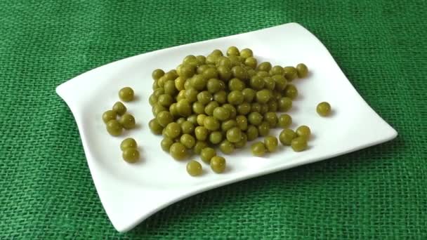 Guisantes verdes en un plato blanco — Vídeo de stock