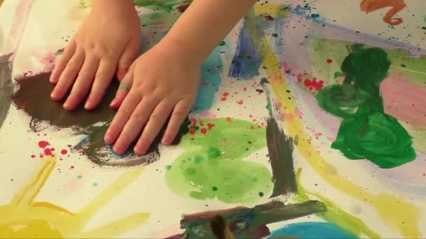 Pittura creativa arte con la piccola mano di una giovane ragazza. Tema dell'infanzia e dell'educazione. Piccola mano di giovane bambina in pittura di carta ad acquerello . — Video Stock