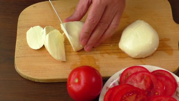 Mozzarella en rodajas con cuchillo sobre tabla de madera — Vídeos de Stock